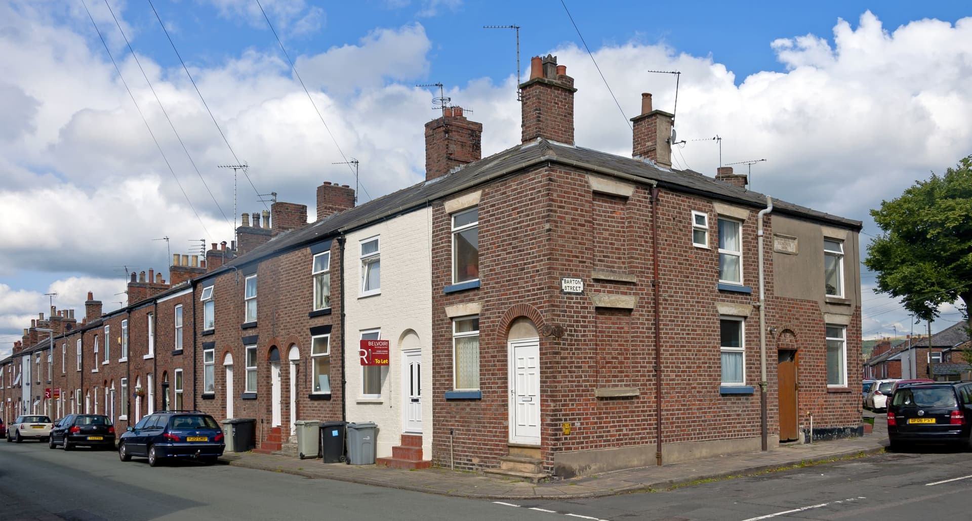 Red-brick terraced houses with slate roofs and chimneys on Barton Street and Newton Street, Macclesfield