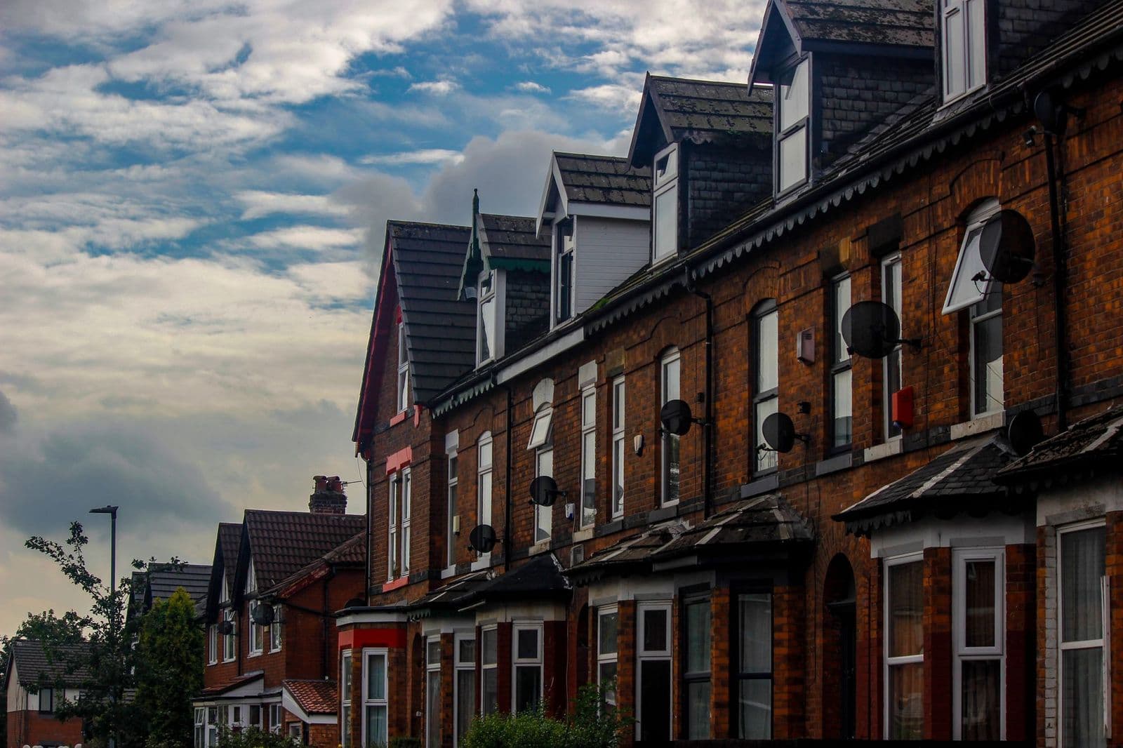 A street of red-brick terraced houses with dormers and chimneys