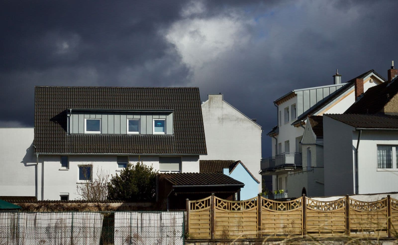 Dark storm clouds gathering over suburban houses