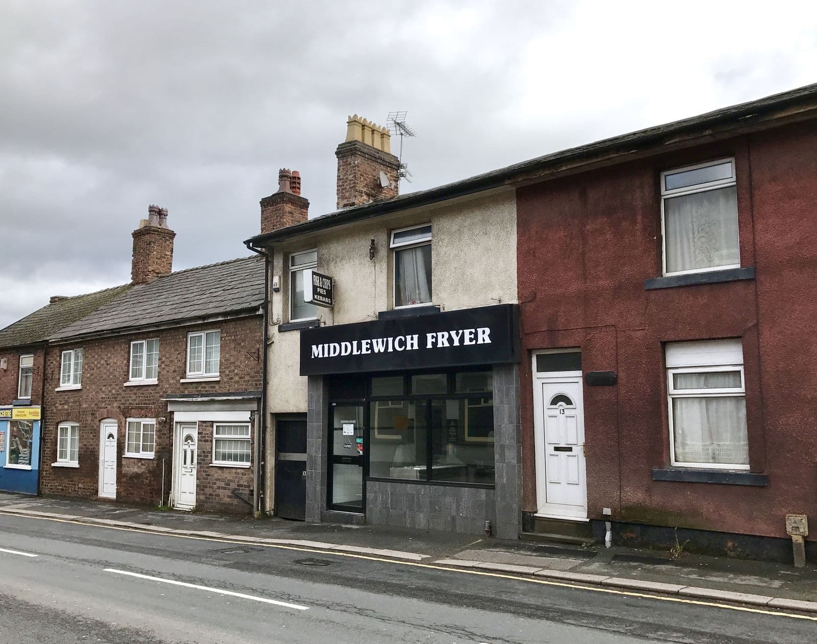 Brick terraced houses and a shop with slate roofs and chimneys in Middlewich