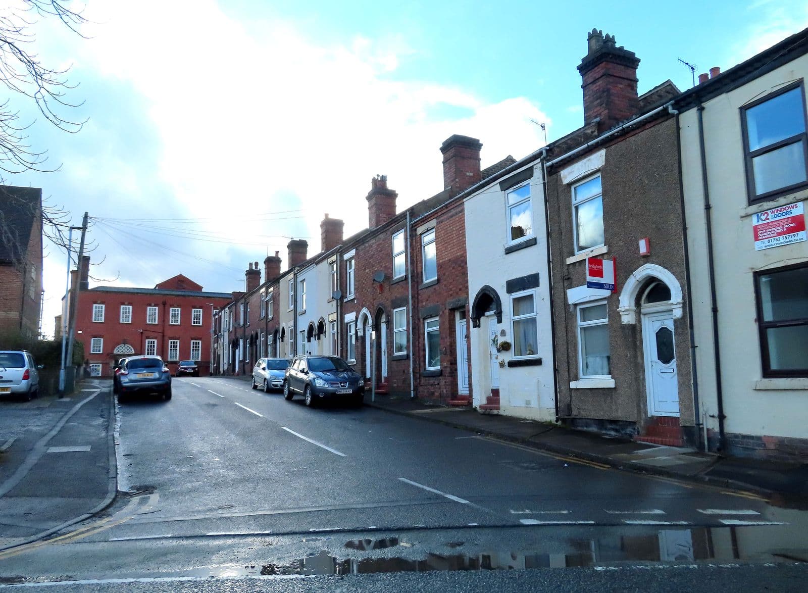 Red-brick terraced houses with chimneys on Nicholas Street, Burslem, Stoke-on-Trent