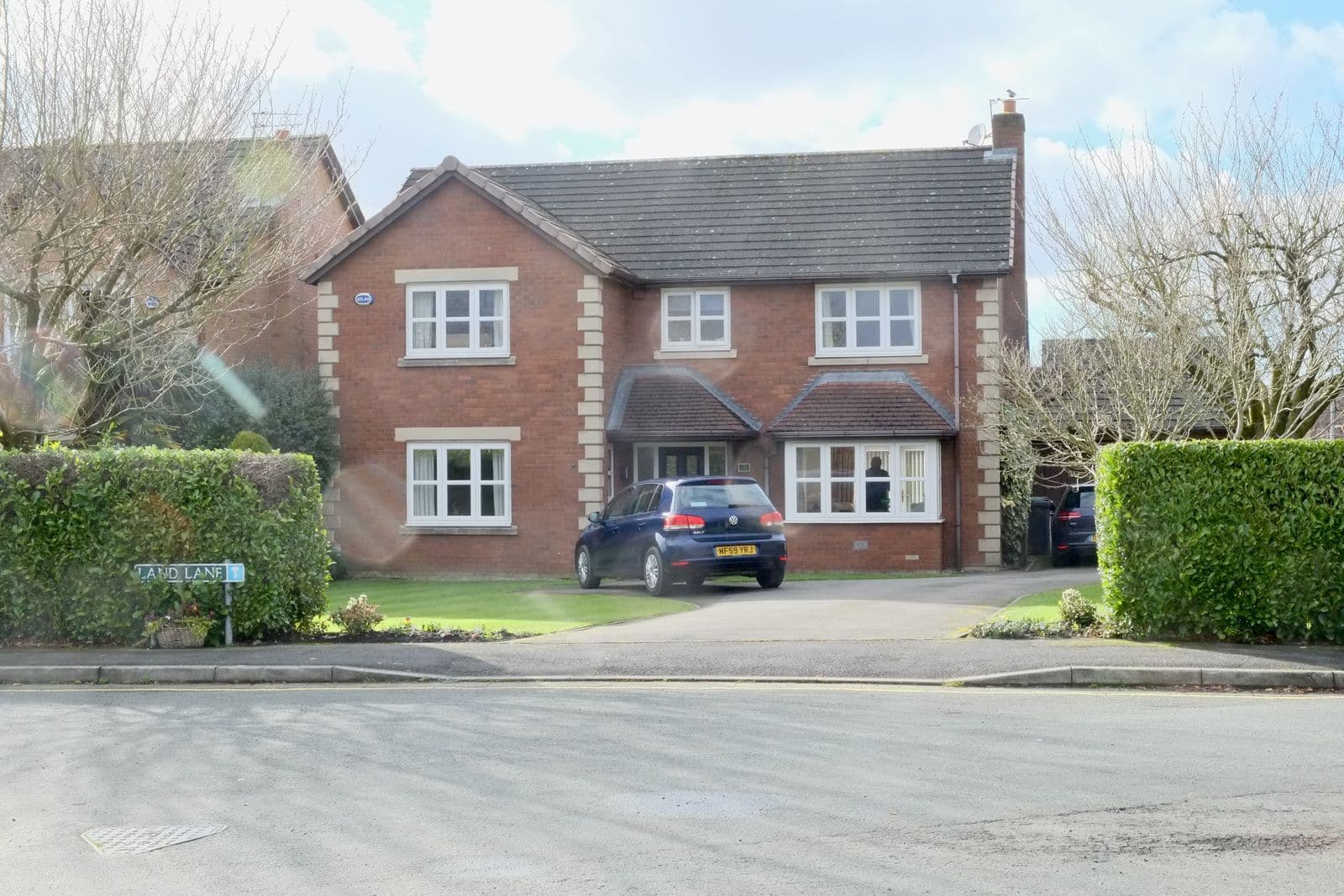 A red-brick detached house with a tiled roof in Wilmslow